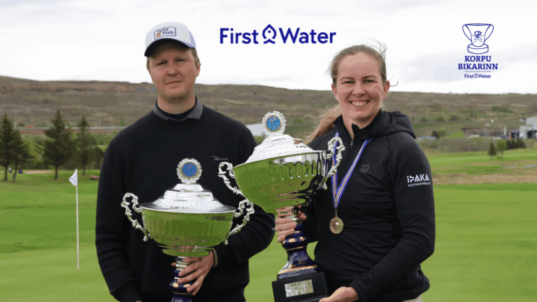 Two athletes on a golf course pose with large trophies, smiles on their faces, First Water logo above and a sponsor crest to the right.