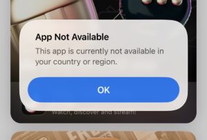 Alert: 'App Not Available' informing the app isn’t available in your country, with a blue OK button.